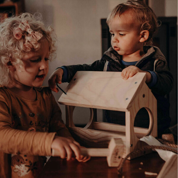 Little brother and sister team busy building their bird feeder.