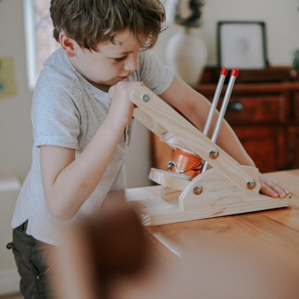 Stumped Can Crusher DIY Kit operated by a boy to show its effectiveness.