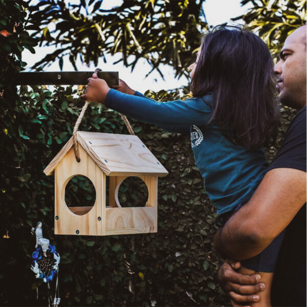 Little girl and dad busy hanging their bird feeder diy kit.