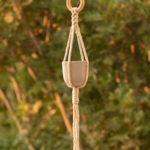 TimTam Macrame plant hanger featured in garden with tree in the backgroung