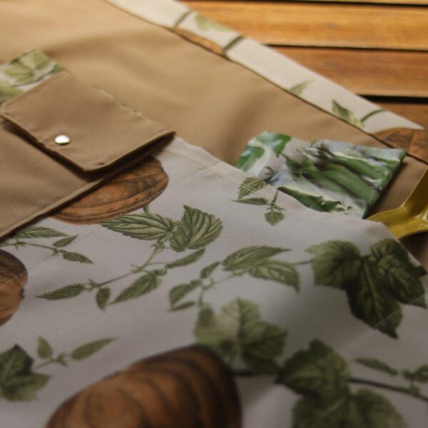 Beige gardening apron with beautiful pocket detail.